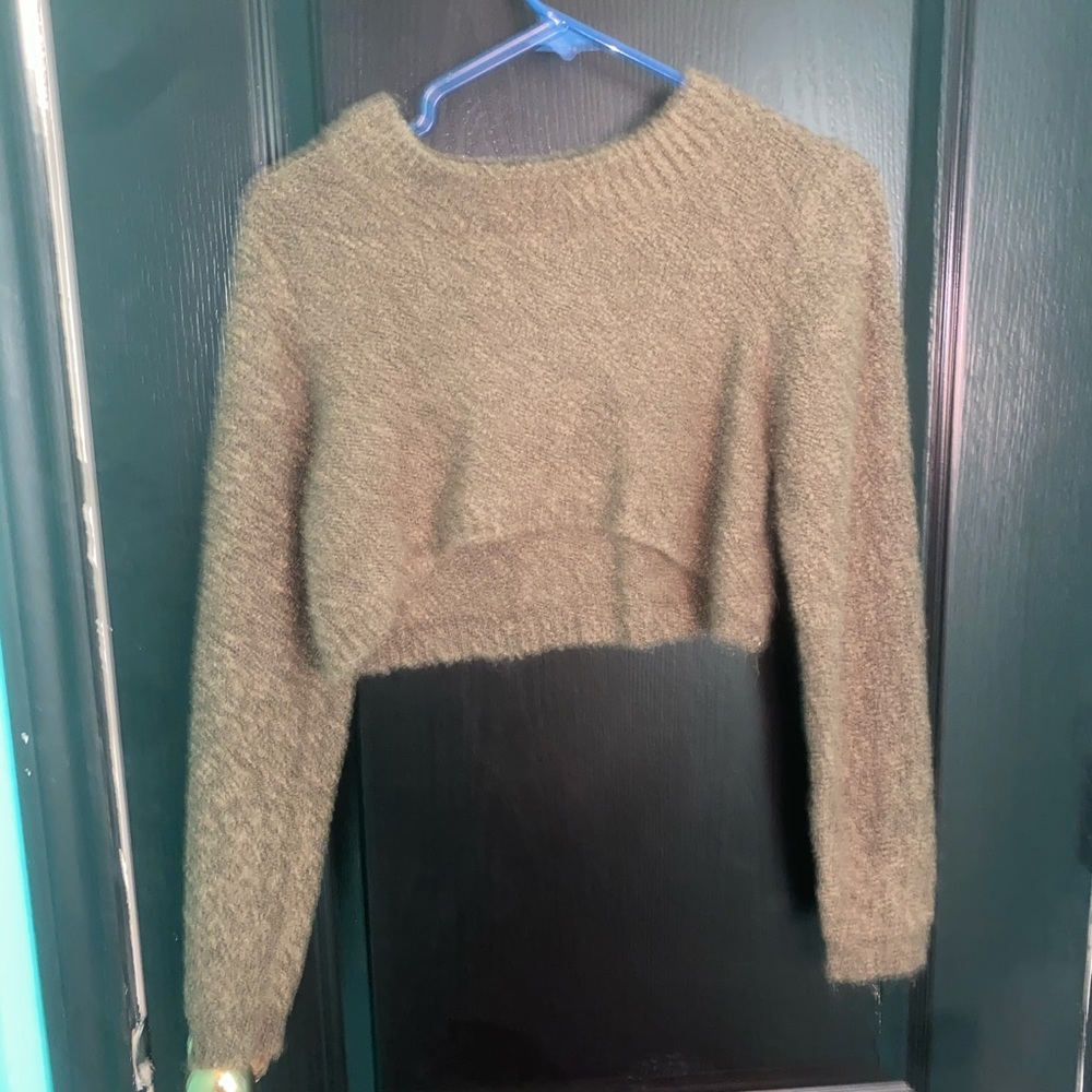 A knitted olive green cropped sweater